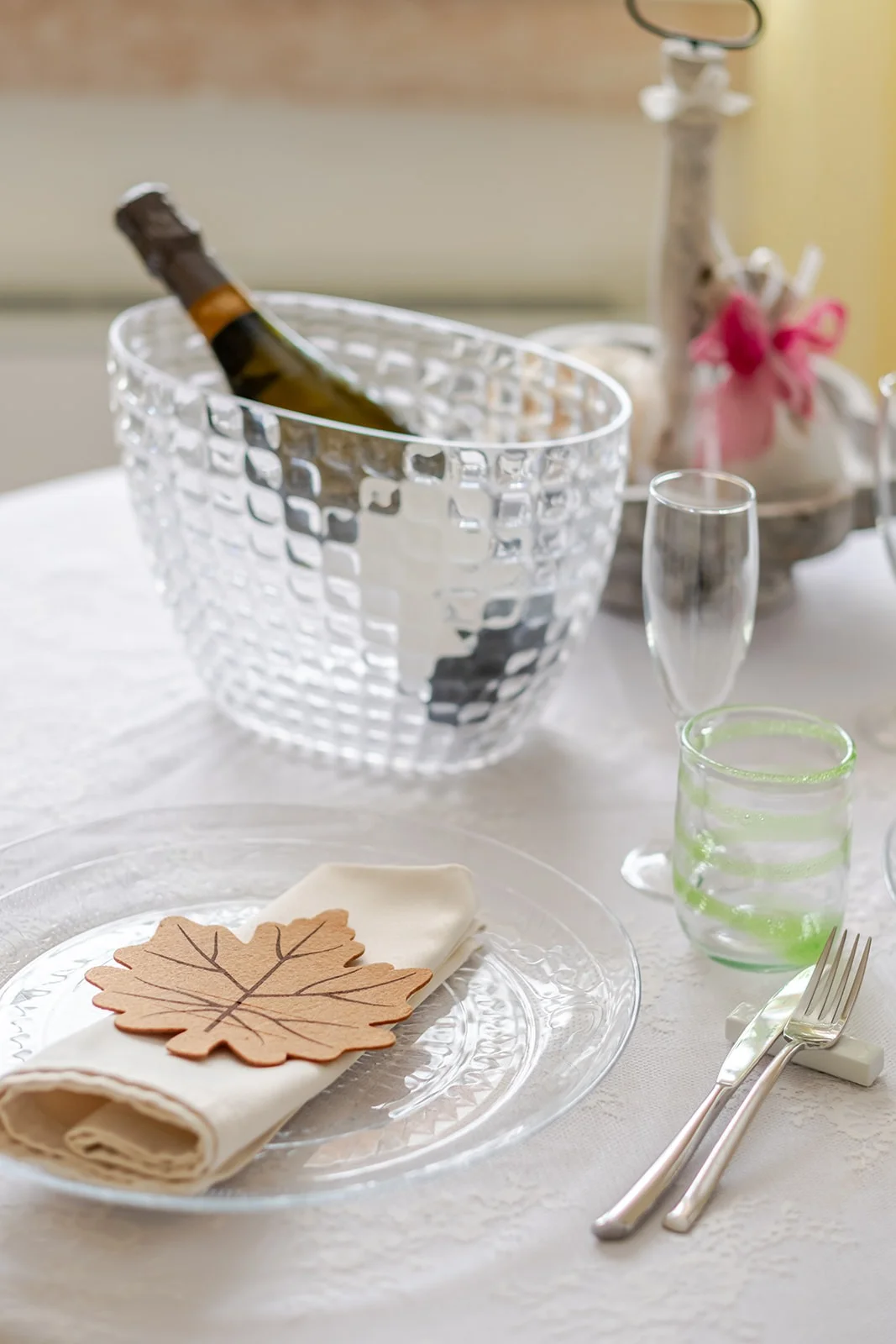 Dettaglio mise en place: champagne in secchiello di cristallo e foglia decorativa Dettaglio mise en place: champagne in secchiello di cristallo e foglia decorativa