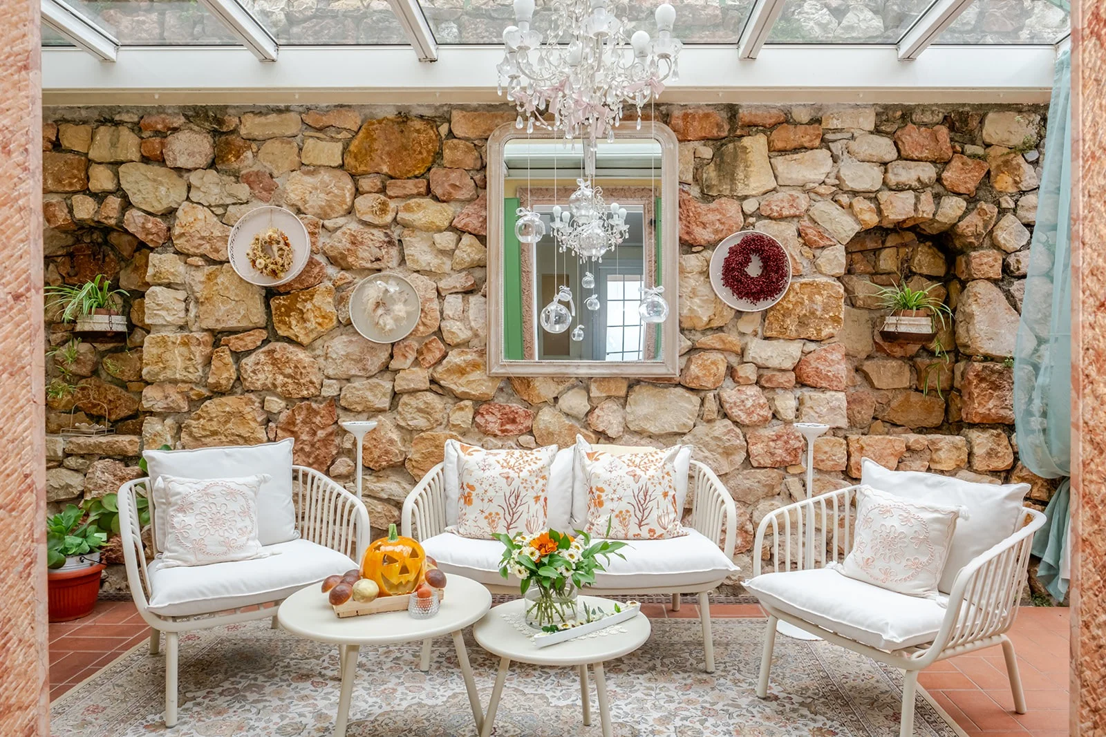 Il salotto-veranda della villa Il salotto-veranda di Le Gemme di Artemisia: muro in pietra, divani, lampadario, decorazioni
